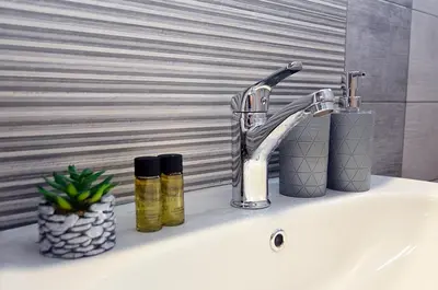 a bathroom sink with a faucet and two soap bottles at eleftheria's apartment in Chania Town