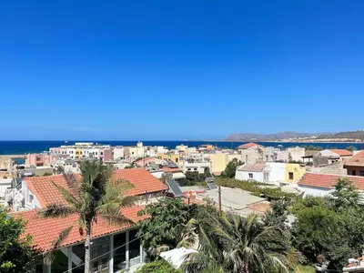 a view of a city with palm trees and the ocean at Venetian Kamara in Old Town Chania in Chania Town