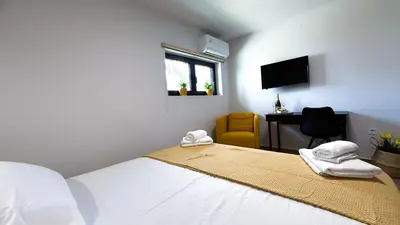 a bedroom with a bed and a desk and a television at Central City Loft by NEK in Chania Town