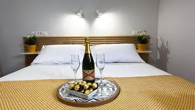 a bottle of wine and two glasses on a bed at Central City Loft by NEK in Chania Town