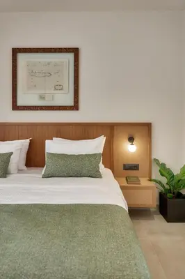 a bedroom with a large bed with a green blanket at Inea Sole Boutique Hotel in Kato Daratso