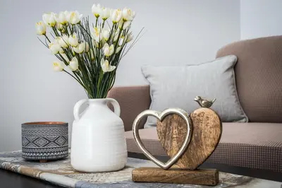 a table with two hearts and a vase with flowers at Kalyves Pearl apartments by the sea in Kalyves
