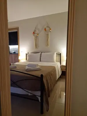 a bedroom with a bed with white sheets and a window at S n G/ Best view apartment in Kissamos