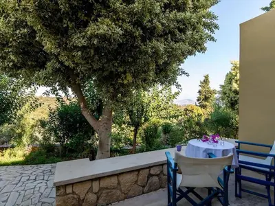 a table and chairs sitting next to a tree at Group accommodation in Crete separate houses in Douliana