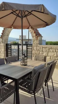 a wooden table with chairs and an umbrella at Ioanna Apartment 1 in Chania Town