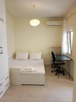 a small bedroom with a bed and a desk at happy travelers studio free parking in Chania Town