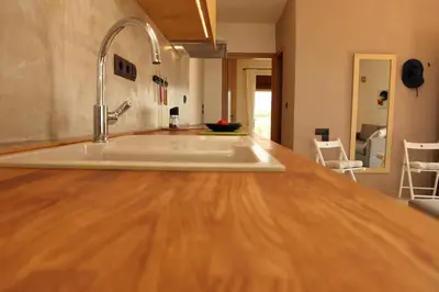 a kitchen with a wooden counter top with a sink at Horizonte Seafront Suites in Kissamos