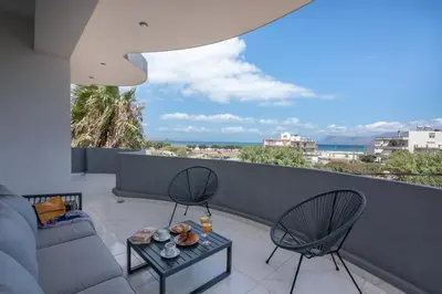 a living room with a couch and chairs on a balcony at Lysithea Apartments - brand new, stylish & central in Kissamos