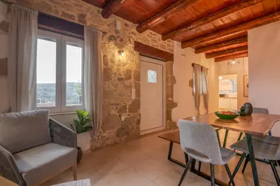 a living room with a table and chairs and a window at Elma's Villa in Kissamos