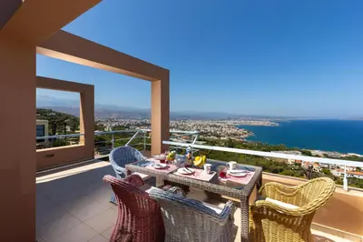 a table and chairs on a balcony with a view of the ocean at Unlimited Blue in Chania Town