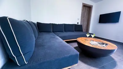 a living room with a blue couch and a wooden table at Ek Ornelakis, Luxury Country House with Jacuzzi in Chania Town