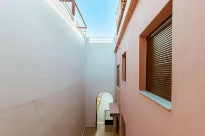 a hallway of a house with a window and a chair at Krinis houses next the old harbour in Chania Town