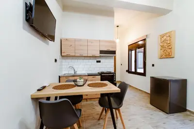 a small kitchen with a wooden table and chairs at Krinis houses next the old harbour in Chania Town