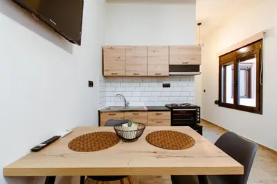 a kitchen with a wooden table in a room at Krinis houses next the old harbour in Chania Town