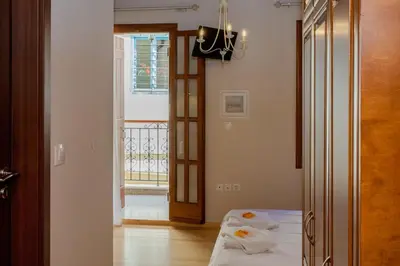 a room with a bed and a hallway with a window at Pleiades Apartments in Chania Town