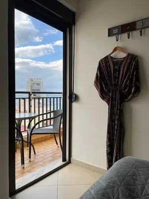 a robe hanging on a wall next to a balcony at Candia Hotel in Chania Town