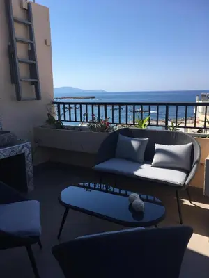 a living room with a view of the ocean at Candia Hotel in Chania Town