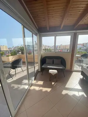 a balcony with a couch and a table and windows at Candia Hotel in Chania Town