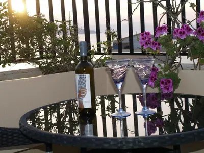 a bottle of wine and two glasses on a table at Candia Hotel in Chania Town
