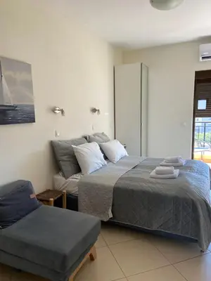 a bedroom with a bed and a chair in it at Candia Hotel in Chania Town