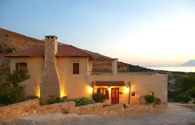 a house with a stone fence in front of it at Patriko Villa in Kissamos