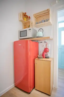 a red refrigerator in a kitchen with a microwave at Little gem by the sea in Chania Town