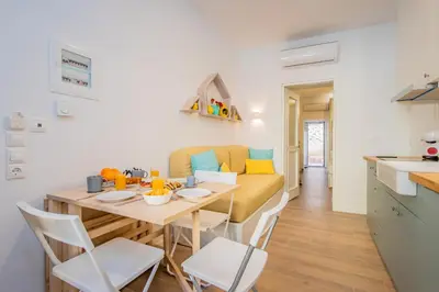 a kitchen and living room with a table and chairs at Oasis by the sea in Chania Town