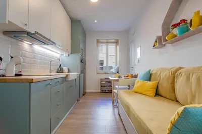 a kitchen and a living room with a couch at Oasis by the sea in Chania Town
