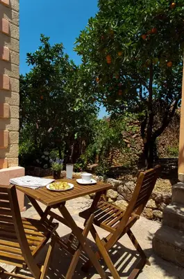 a wooden table and two chairs sitting next to a tree at Citrea Villa in Fournés