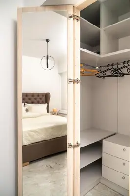 a bedroom with a bed and a mirror at EDEL Suite in Chania Town