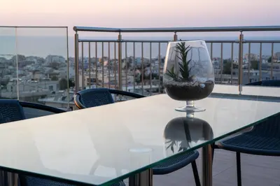 a table with a plant in a wine glass on a balcony at EDEL Suite in Chania Town