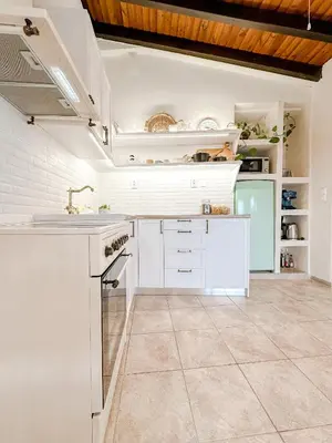 a kitchen with white cabinets and a sink at Mountain Bliss Guesthouse 1 next to Sougia in Agrilés