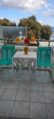 a white table with a vase of flowers on it at Papidakis Studios in Agia Marina Nea Kydonias