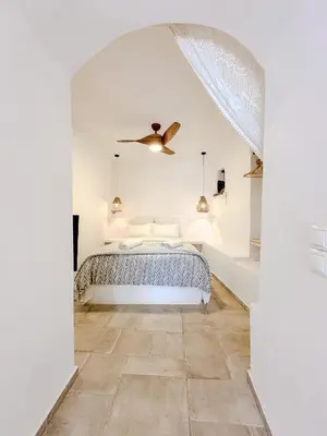 a white bedroom with a bed and a ceiling fan at Mountain Bliss Guesthouse 2 next to Sougia in Agrilés
