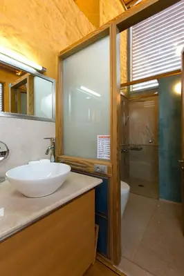 a bathroom with a sink and a toilet and a shower at Seafront Ravdoucha Epavlis Athina Villa - Pool, Gym, Sauna, Private Parking, WiFi in Ravdhoúkha