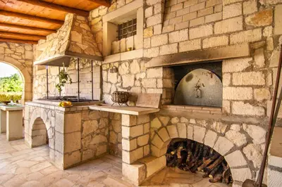 a stone fireplace in a room with a stone wall at Villa Marianna in Vryses