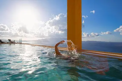 a person in a swimming pool in the water at Beachfront Ravdoucha Epavlis Eleni Villa - Pool, Hot Tub, Gym, Sauna, Private Parking, WiFi in Chania Town