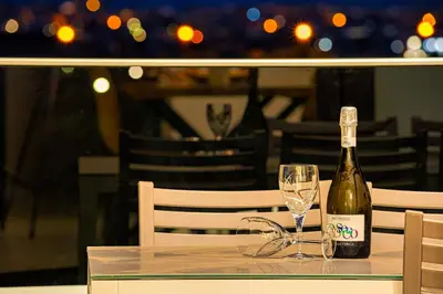 a bottle of wine sitting on a table with a glass at Chris villa with private ecologic pool and kid's playground! in Chania Town