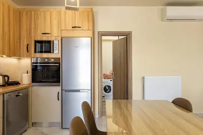 a kitchen with a table and a refrigerator at Chris villa with private ecologic pool and kid's playground! in Chania Town