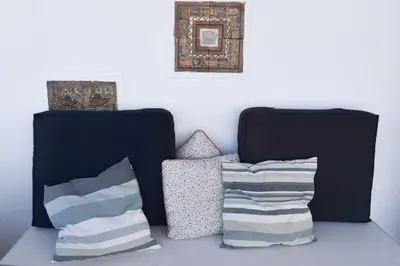 two pillows and a picture on a white wall at Seasound apartments in Galatás
