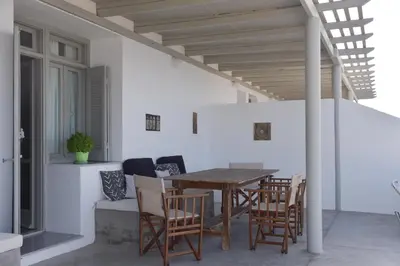a patio with a wooden table and chairs at Seasound apartments in Galatás