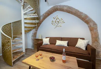 a living room with a couch and a table at DELUXE MAISONETTE in Chania Town