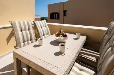 a table with a bowl of fruit on a balcony at DELUXE MAISONETTE in Chania Town