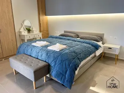 a bedroom with a large bed with a blue comforter at Veryhome in Maleme