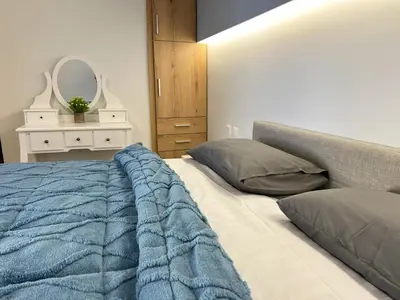 a bedroom with a bed with a blue blanket and a mirror at Veryhome in Maleme