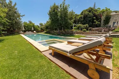 a row of chaise lounges next to a swimming pool at Athermigo Boutique Estate in Gavalochori