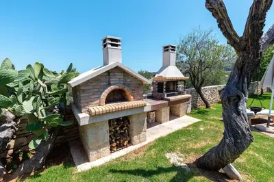 a stone oven in a garden with a tree at Athermigo Boutique Estate in Gavalochori