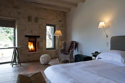 a bedroom with a bed and a fire place at Athermigo Boutique Estate in Gavalochori