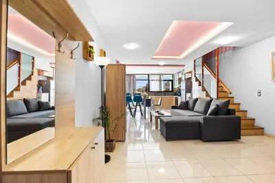 a living room with two couches and a staircase at Emmanouel Maisonette near the Sea in Parigoría
