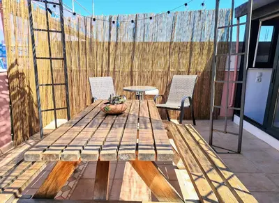a wooden table and two chairs on a patio at Icarus Loft Old Town rooftop terrace in Chania Town